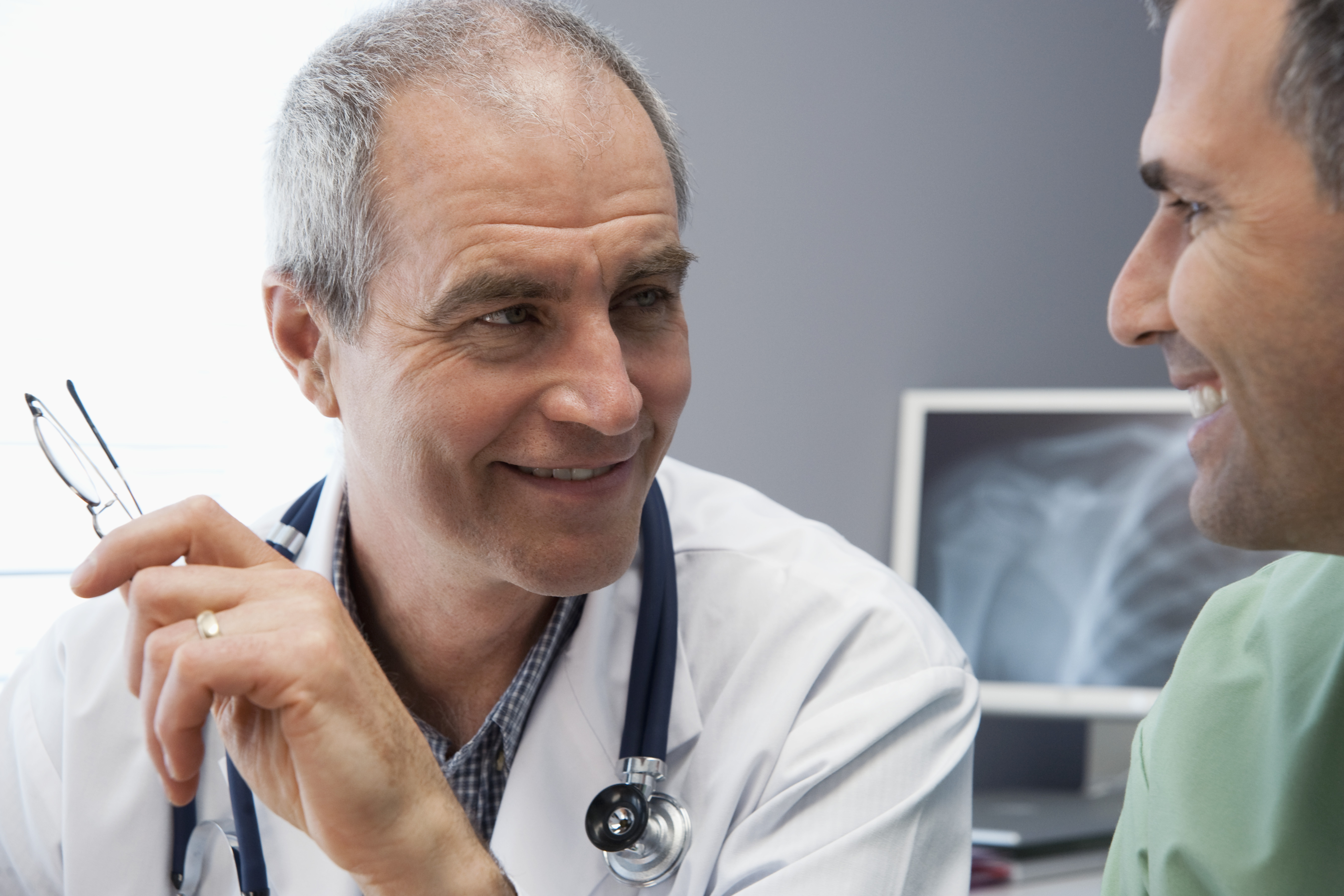 A doctor talking with a patient. Both are smiling.