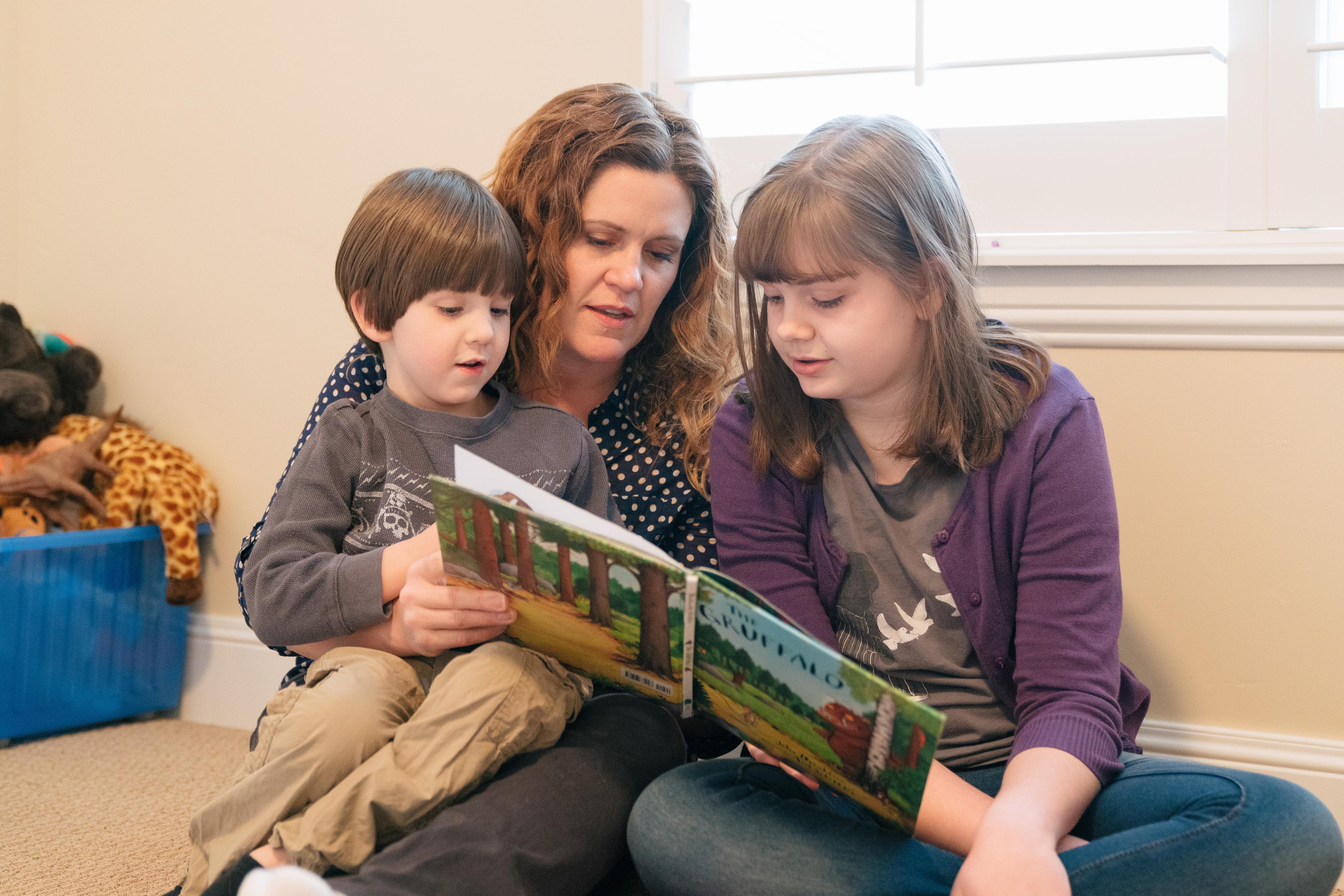Heidi Wallis reading to her two children, both of whom have GAMT deficiency