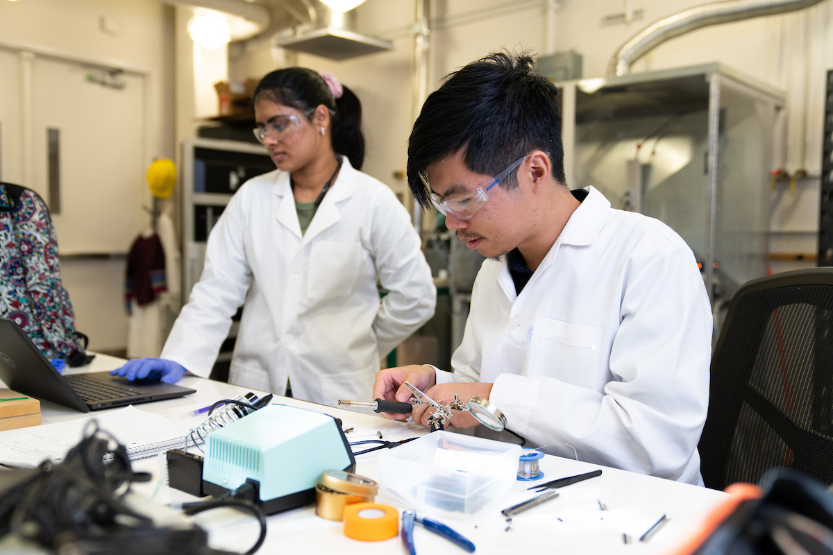 Postdoctoral researcher Kamaljeet Kaur, left, and undergraduate Dillon Tang calibrate devices in the lab.