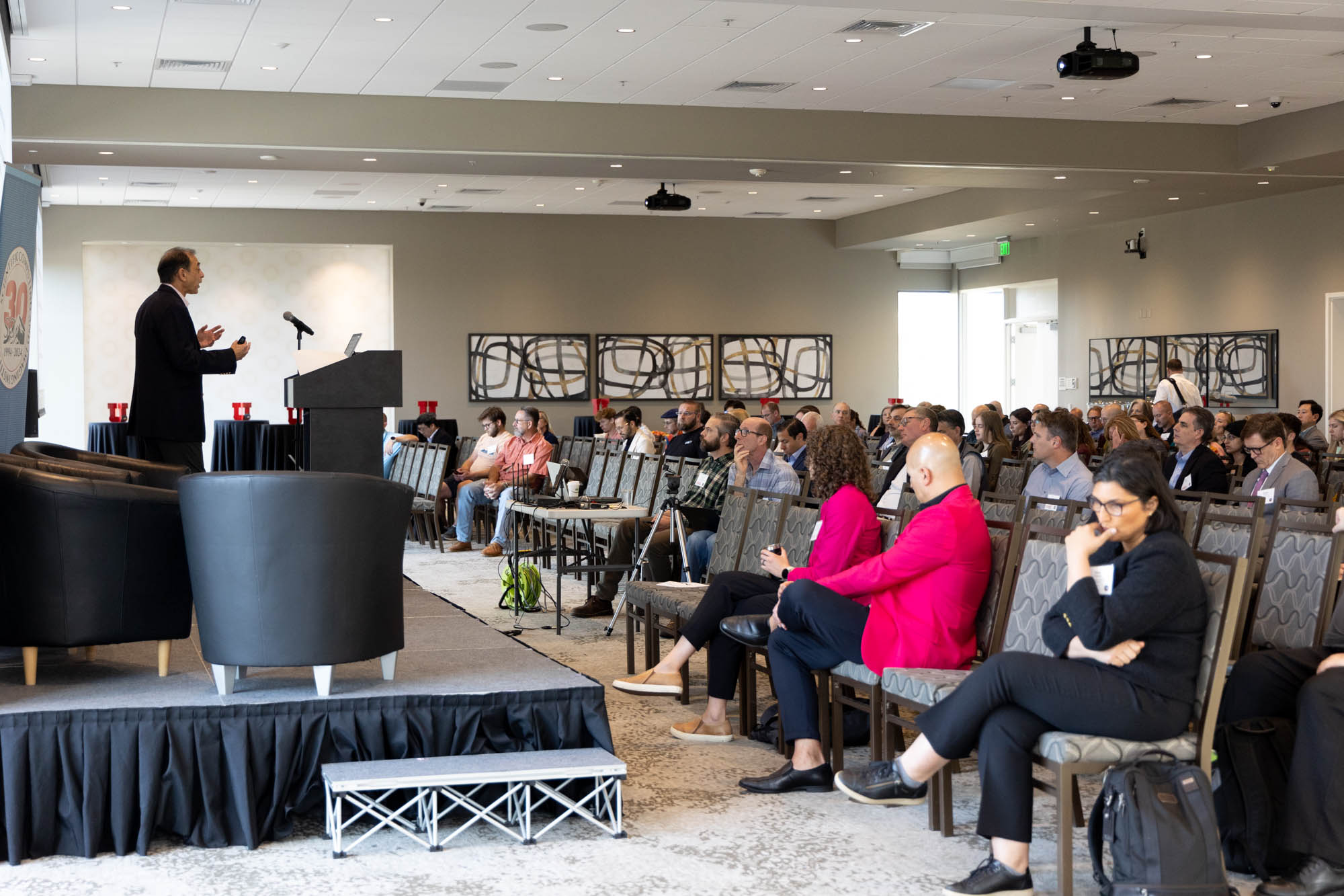 A man in a suit speaks with feeling to a packed audience.