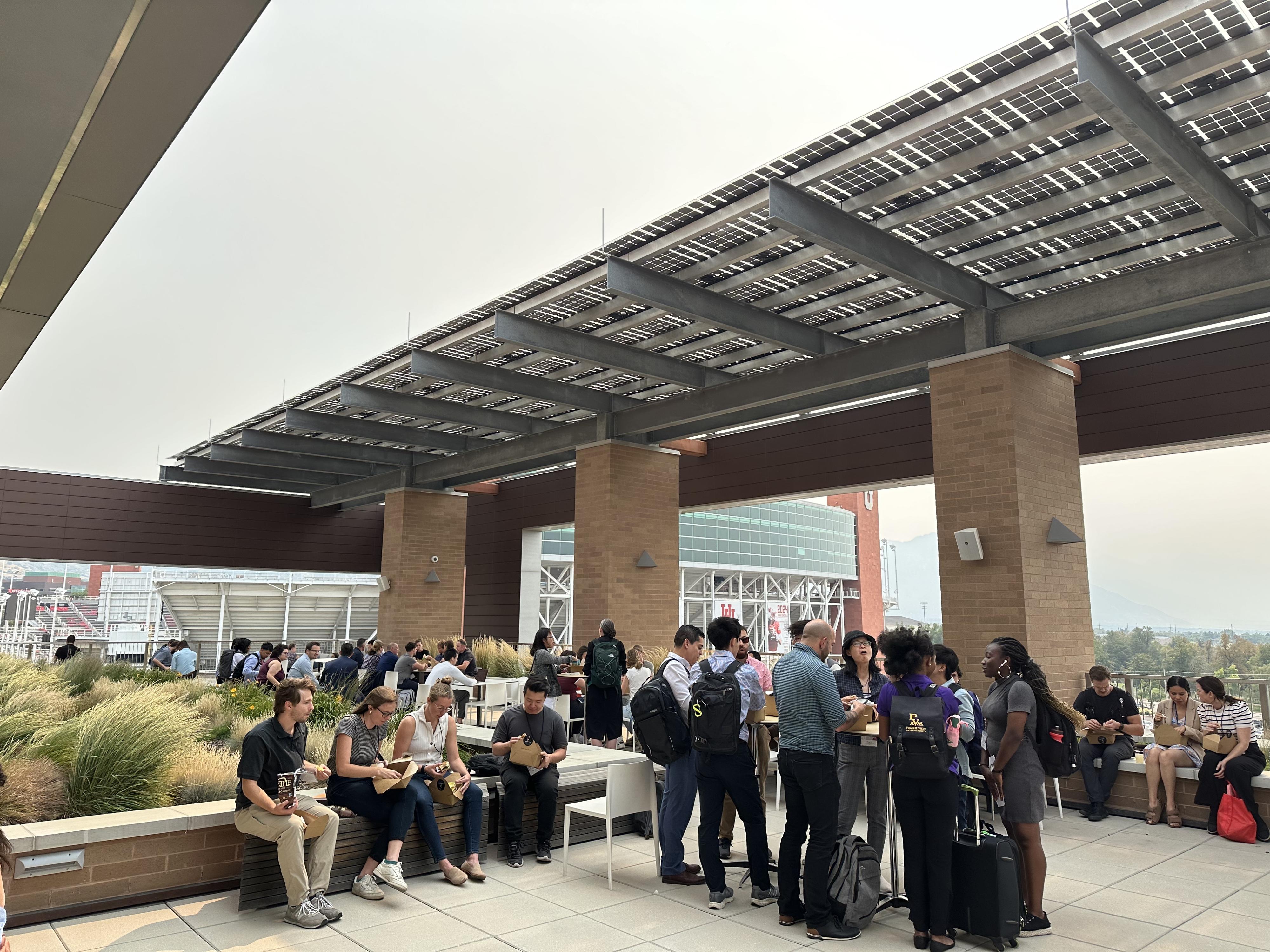 Researchers eat lunch and converse outside.
