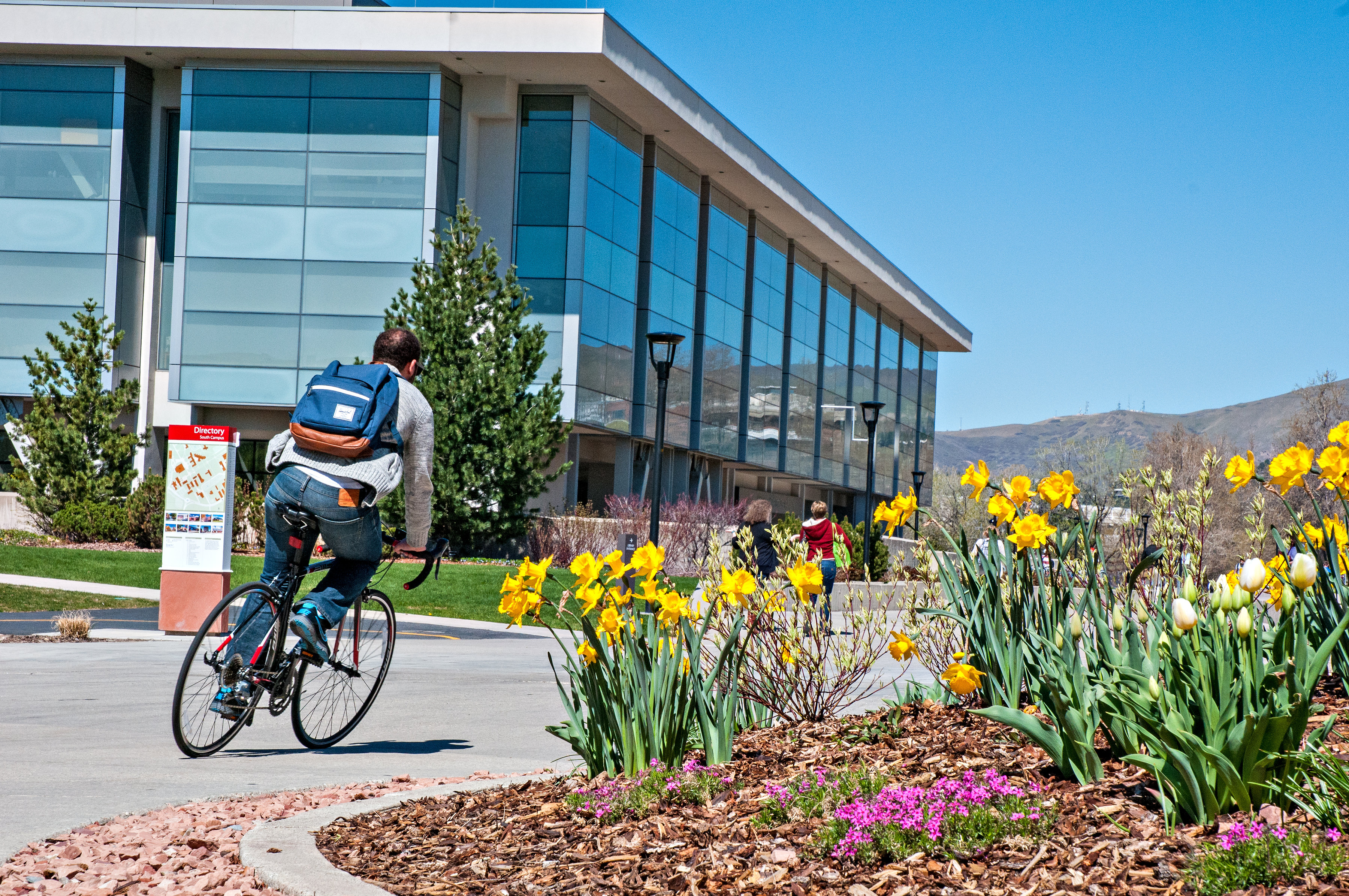 Person riding bike through campus in the spring