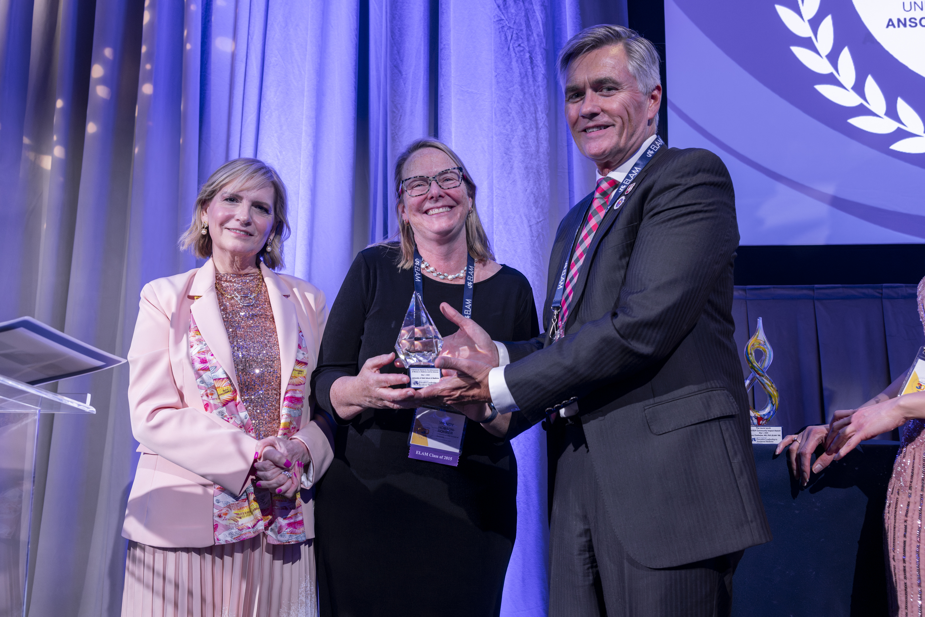 Wendy Hobson-Rohrer (middle) and former U of U Health CEO and Senior Vice President Michael Good (right) accept the Institutional Award for the Advancement of Women in Medicine and the Sciences at the 30th anniversary celebration for the Executive Leadership in Academic Medicine (ELAM) program, May 2025. 