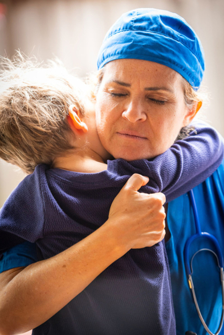 Health care professional hugging her son