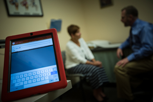 Darrel Brodke, MD, with patient discussing patient reported outcomes