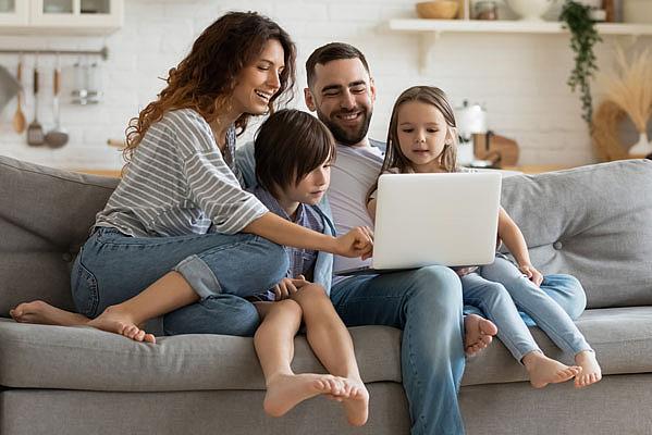 Family sitting on couch looking at laptop