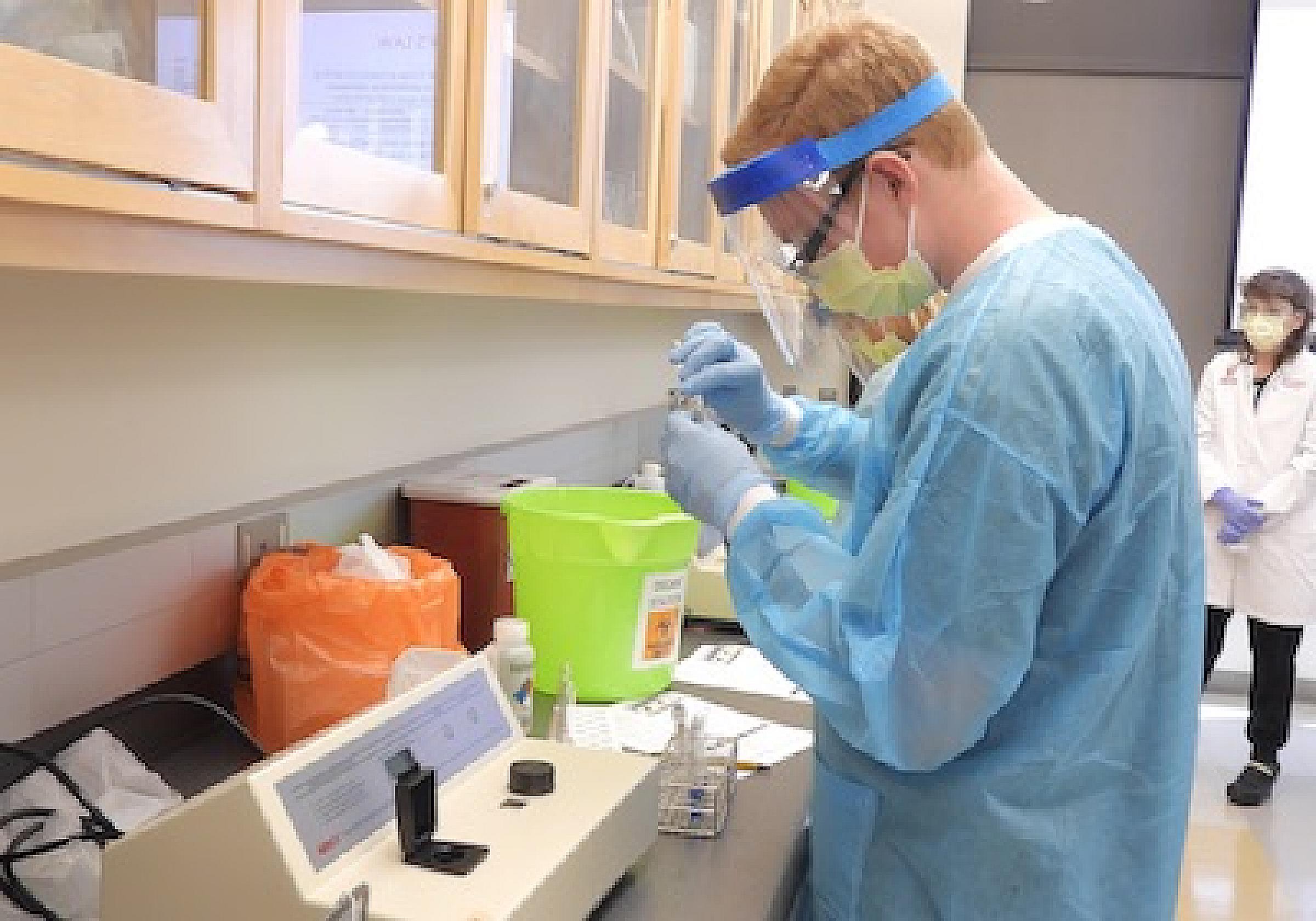 Lab student in PPE performing tests