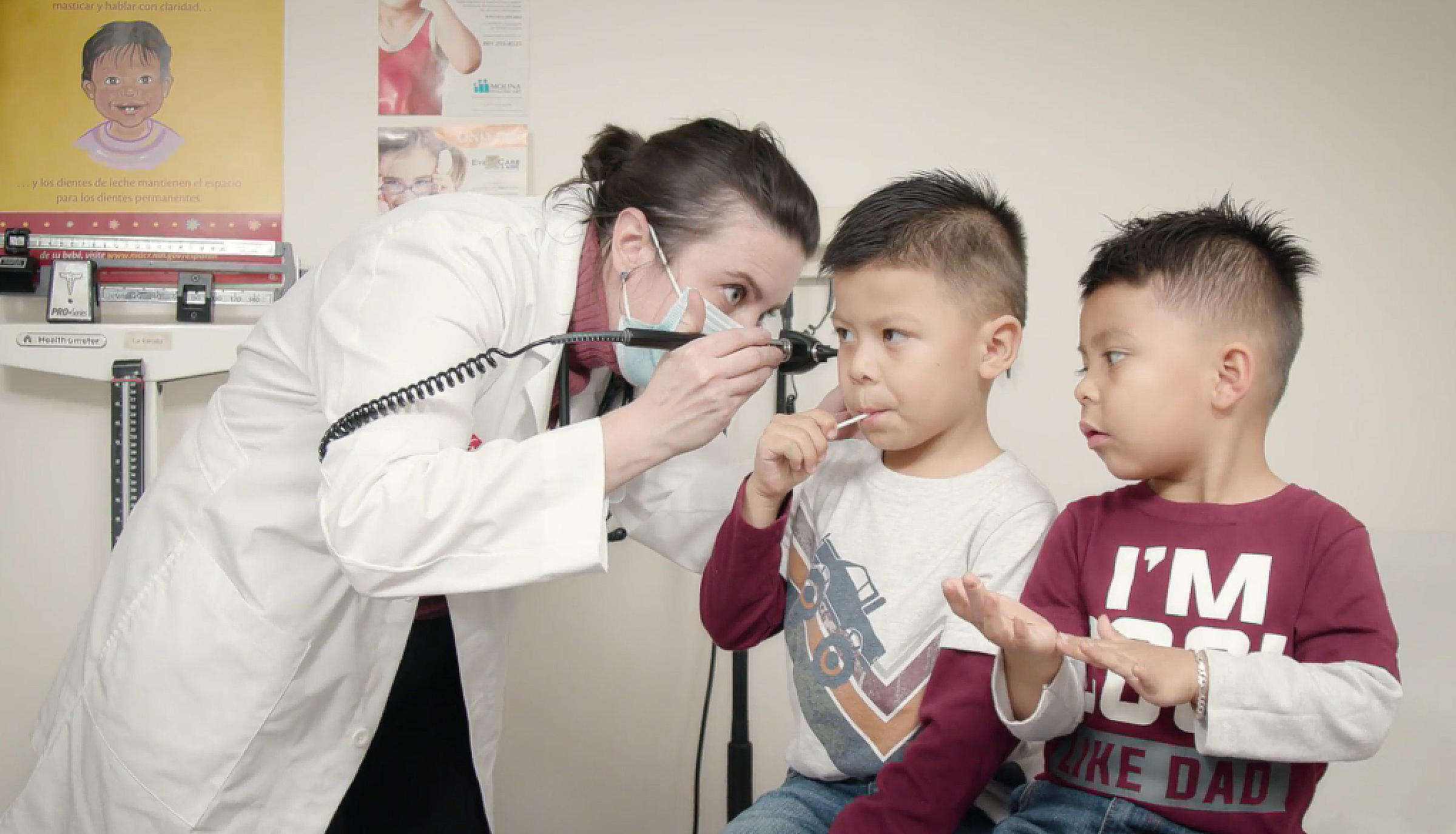 Student doctor examining children's ears, Midvale