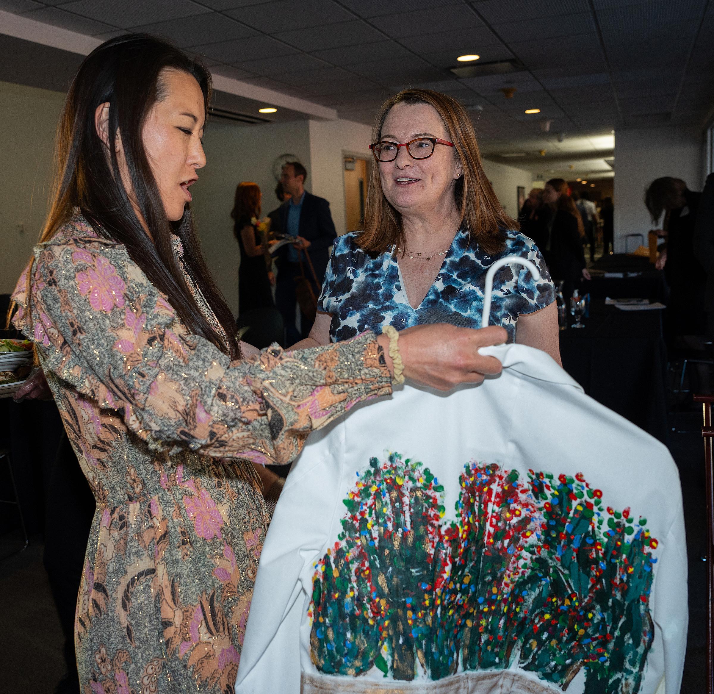 Gretchen Case with Joni Aoki (MD 2024) and the artwork Aoki created from a physician’s white coat in Case’s elective course “Art in Medicine/Medicine in Art.”