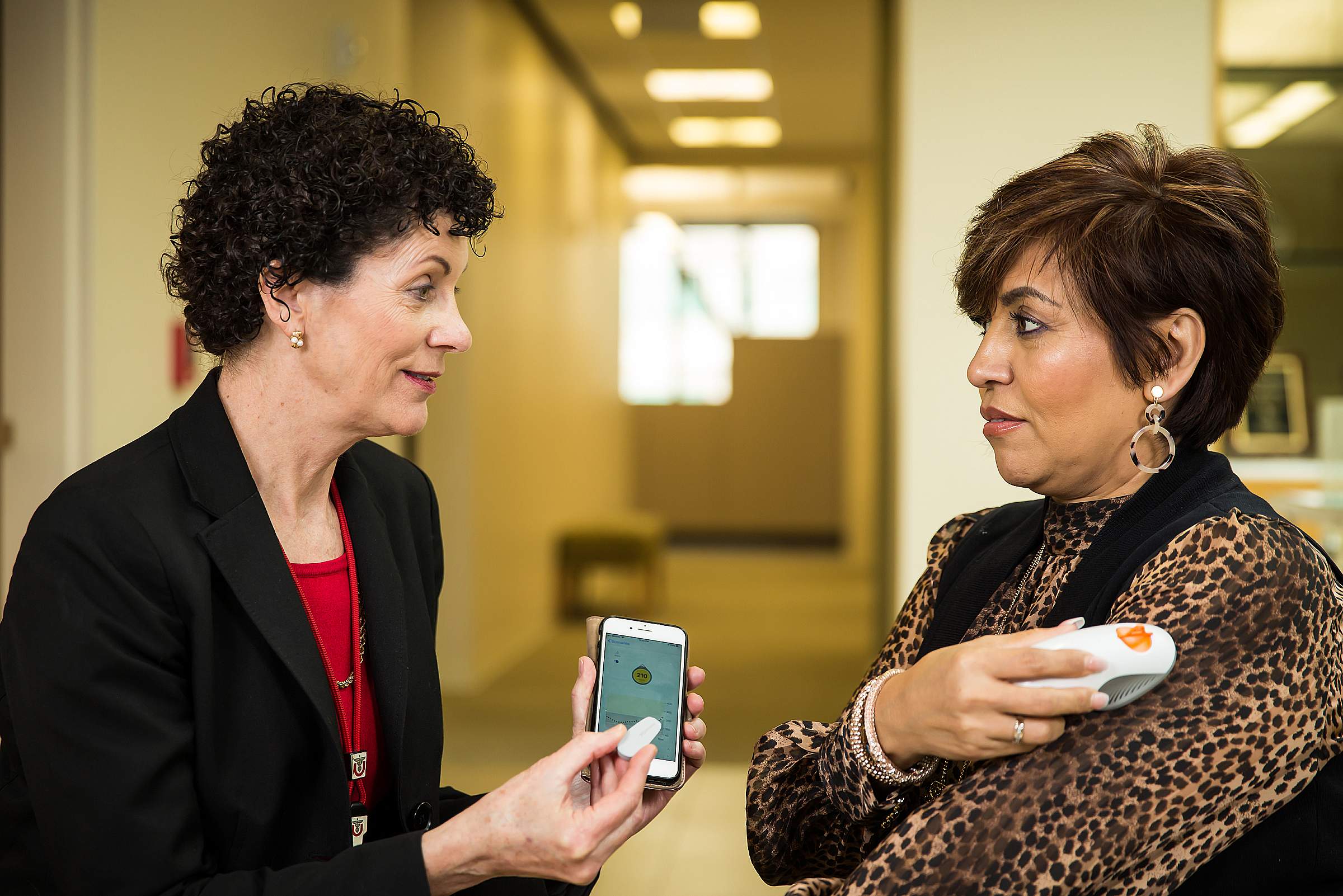 Nancy Allen with Jeanette Villalta demonstrating glucose monitoring device at the University of Utah College of Nursing. 