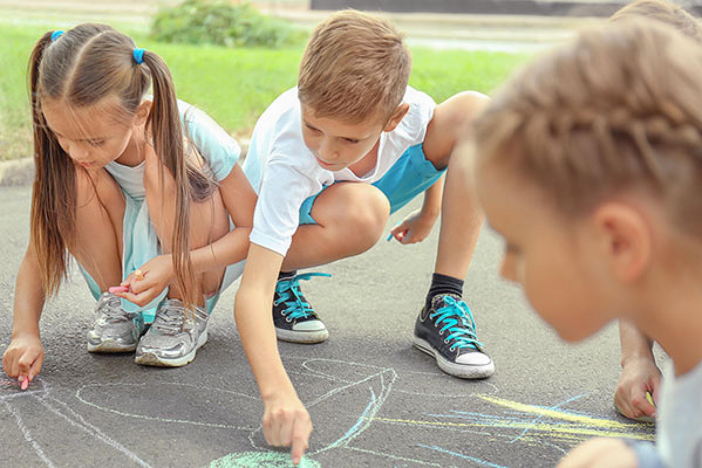 Children drawing on sidewalk with chalk