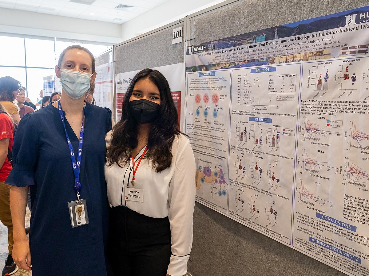Arabella Young, PhD (left) and Jessica Venegas (right) stand in front of Jessica's poster at the Summer Symposium