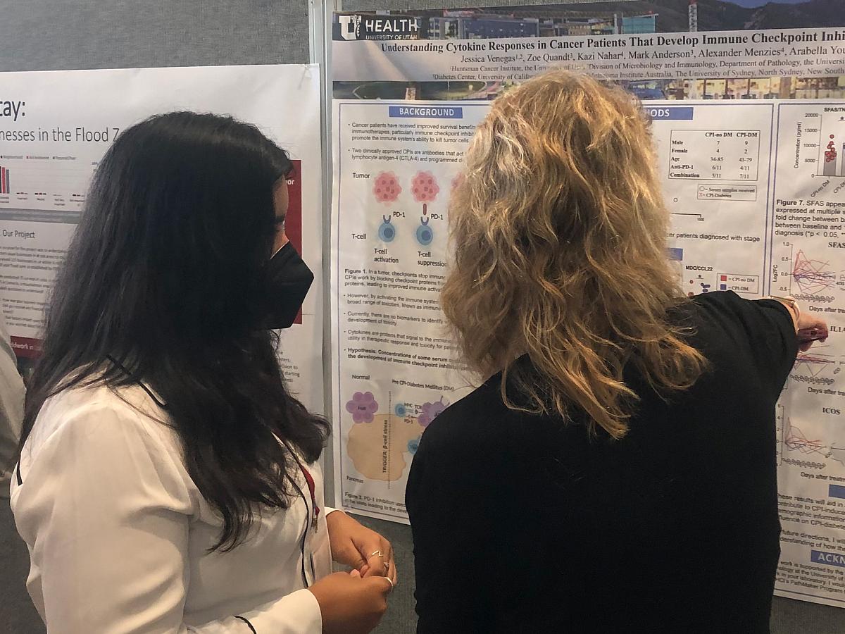 Jessica Venegas talks about her PathMaker poster with Summer Symposium attendee