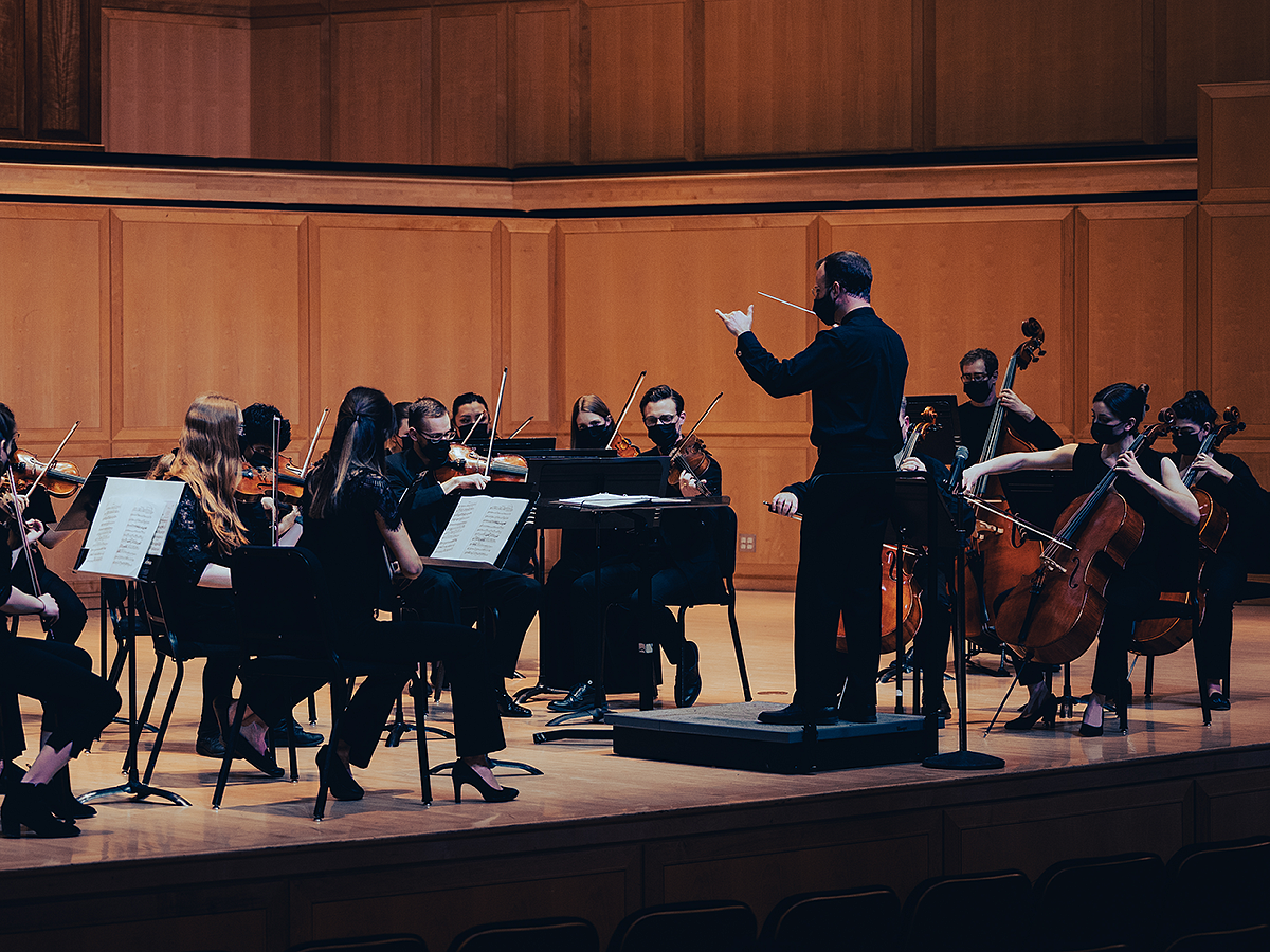 A conductor leading an orchestra during a performance.