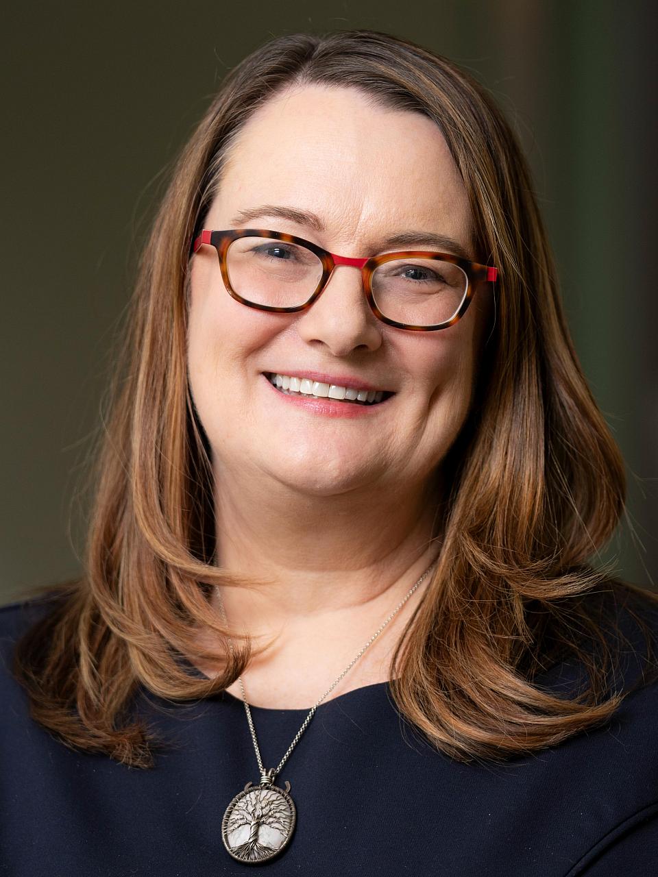 Gretchen Case, with glasses and brown hair.