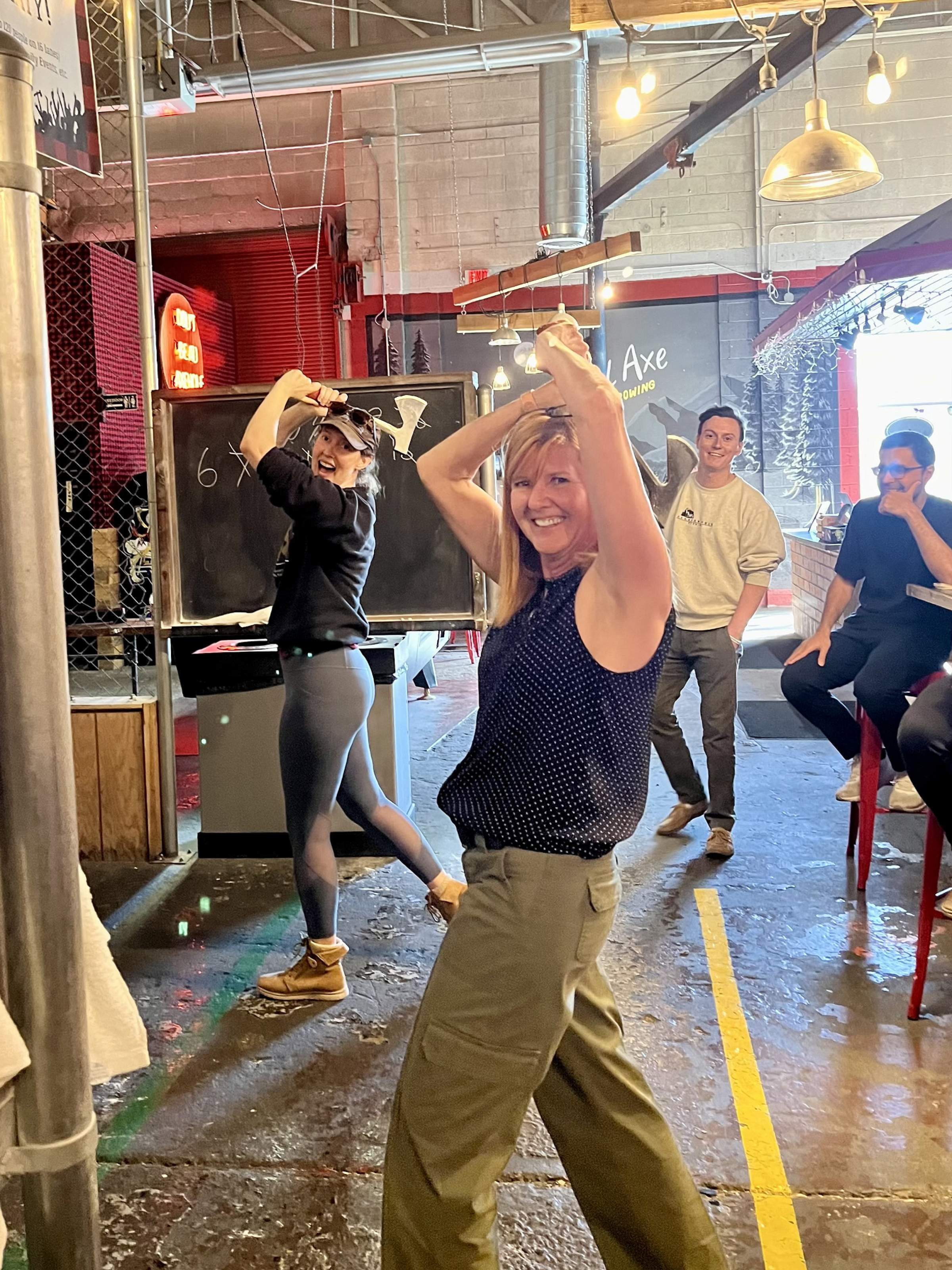 Young Lab members paused mid-throw while throwing axes
