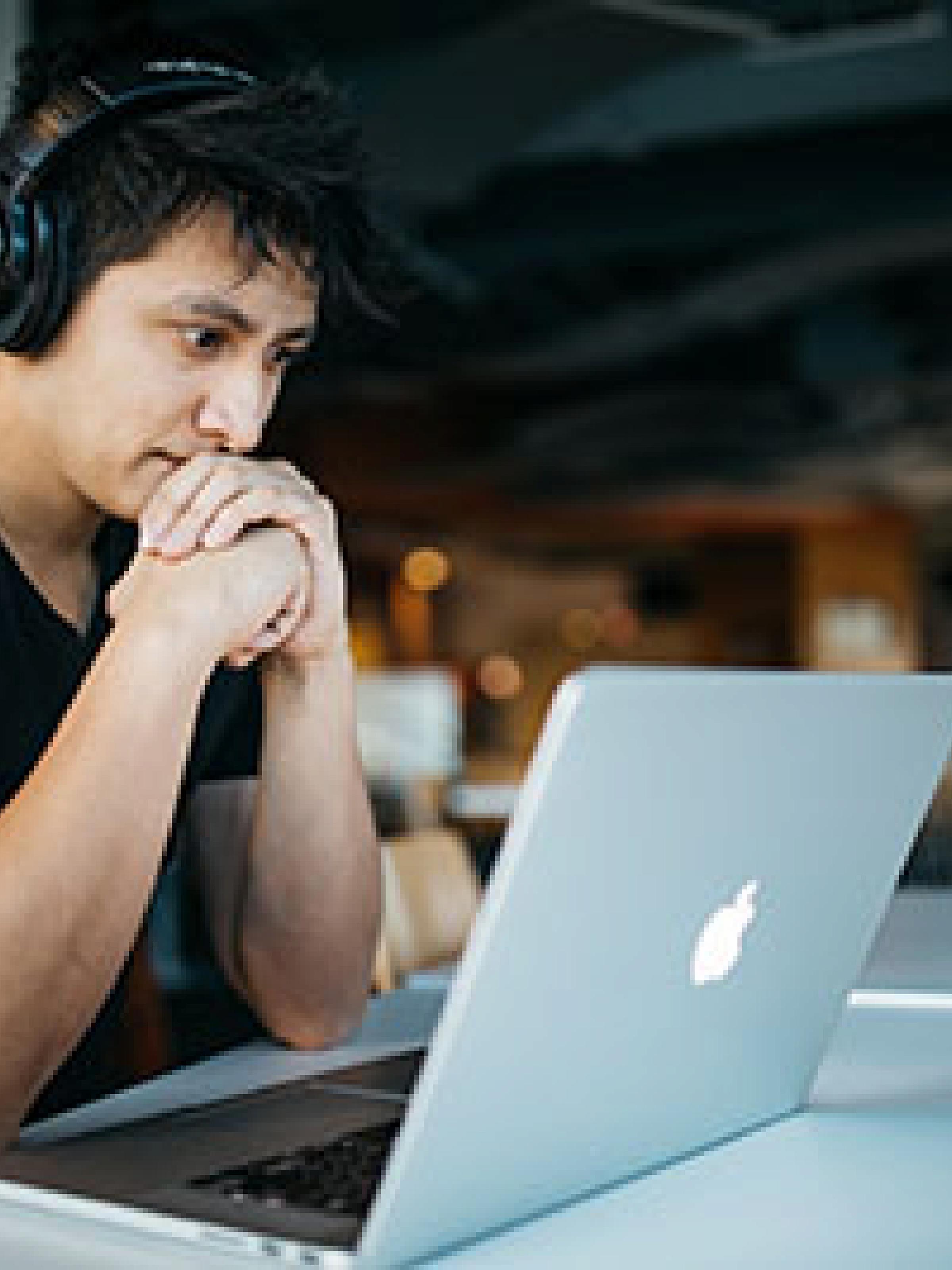 Man with headphones looking at a laptop