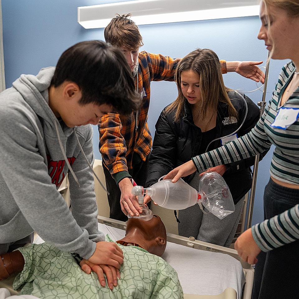 Saturday Academy participants practice CPR on a simulation mannequin