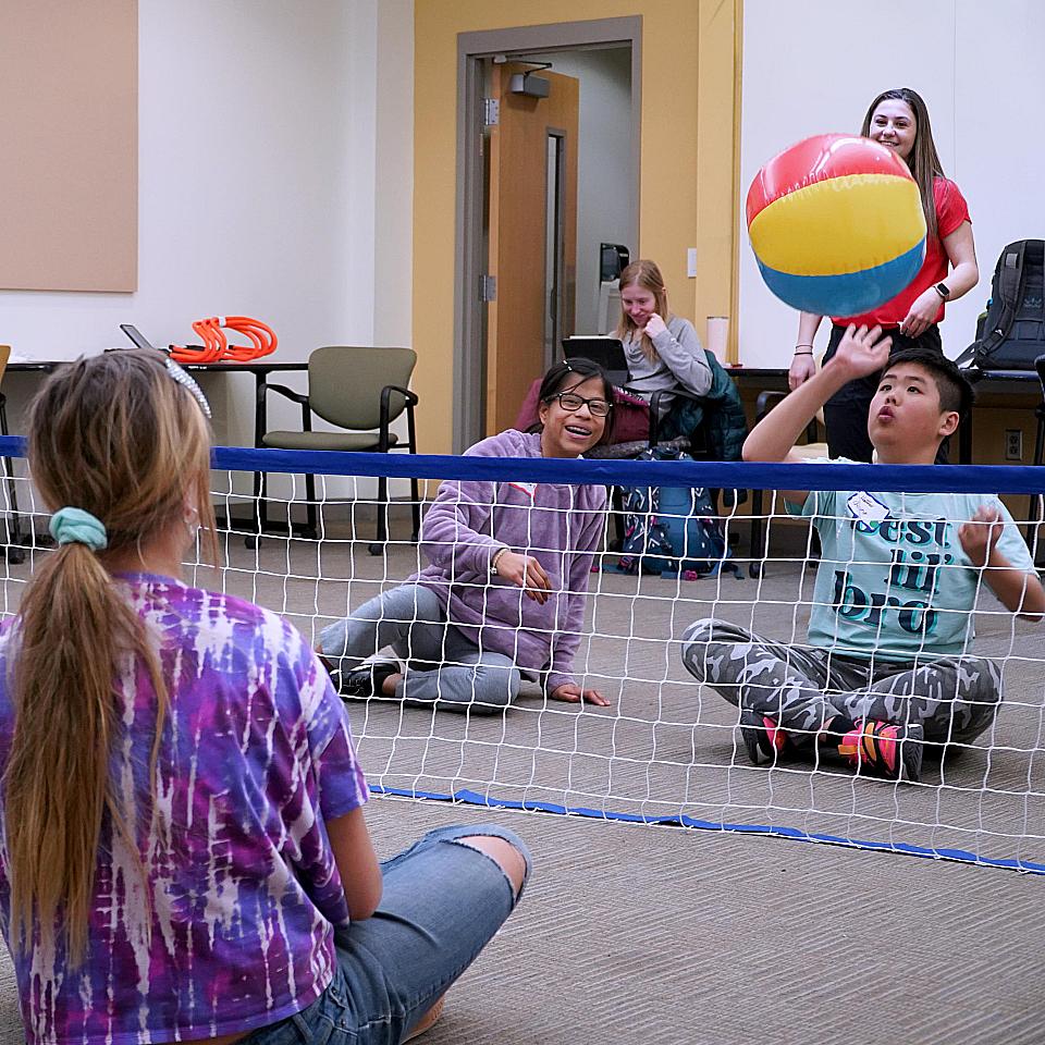 Saturday Academy students practice hand-eye coordination with a beachball