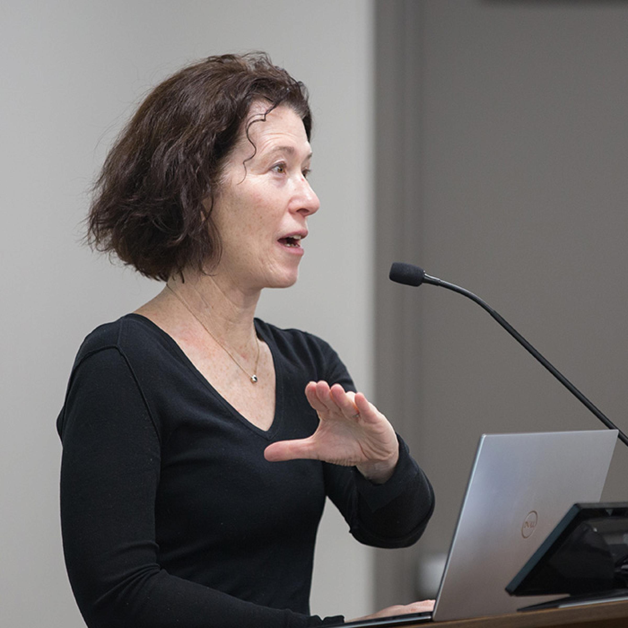 Person in Black Shirt Giving Lecture at Podium