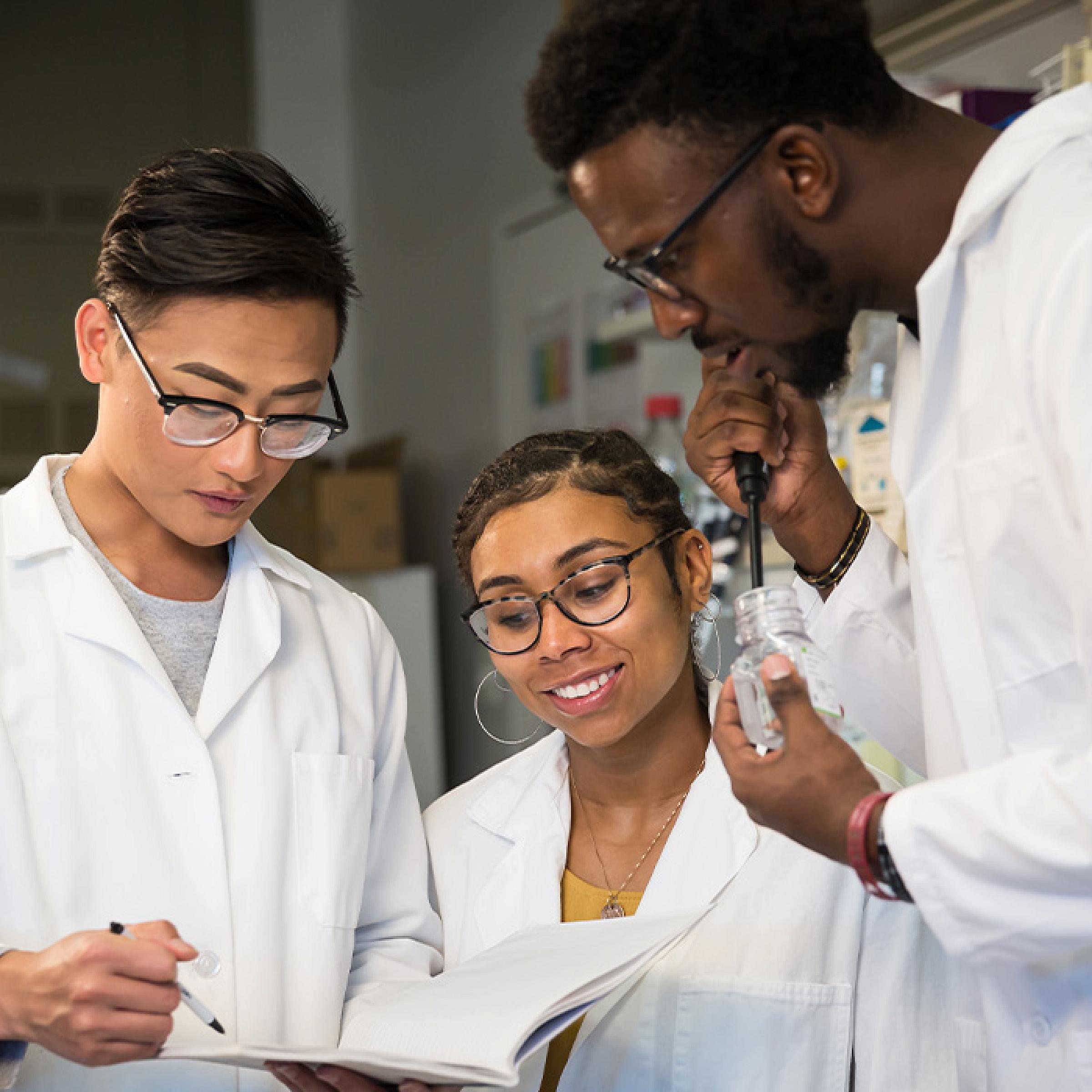 Three People with Lab Coats in Research Lab