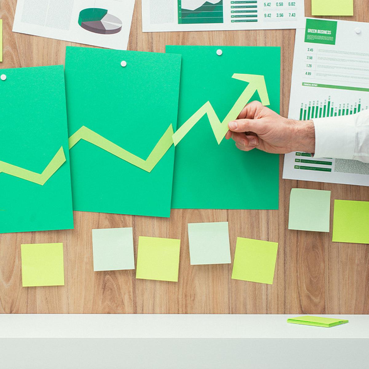 Finance Stock Image with Green Arrow, Sticky Notes, Charts, and Graphs