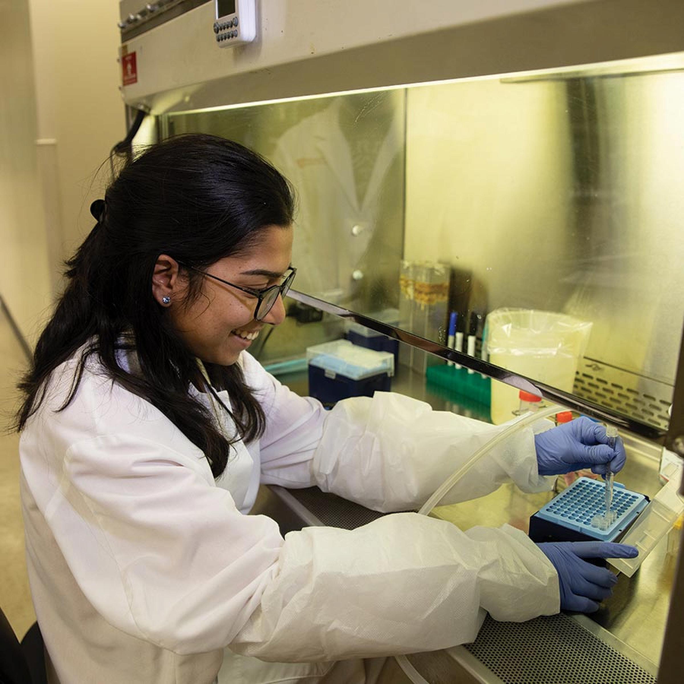 Graduate School Researcher in Lab Coat using Fume Hood