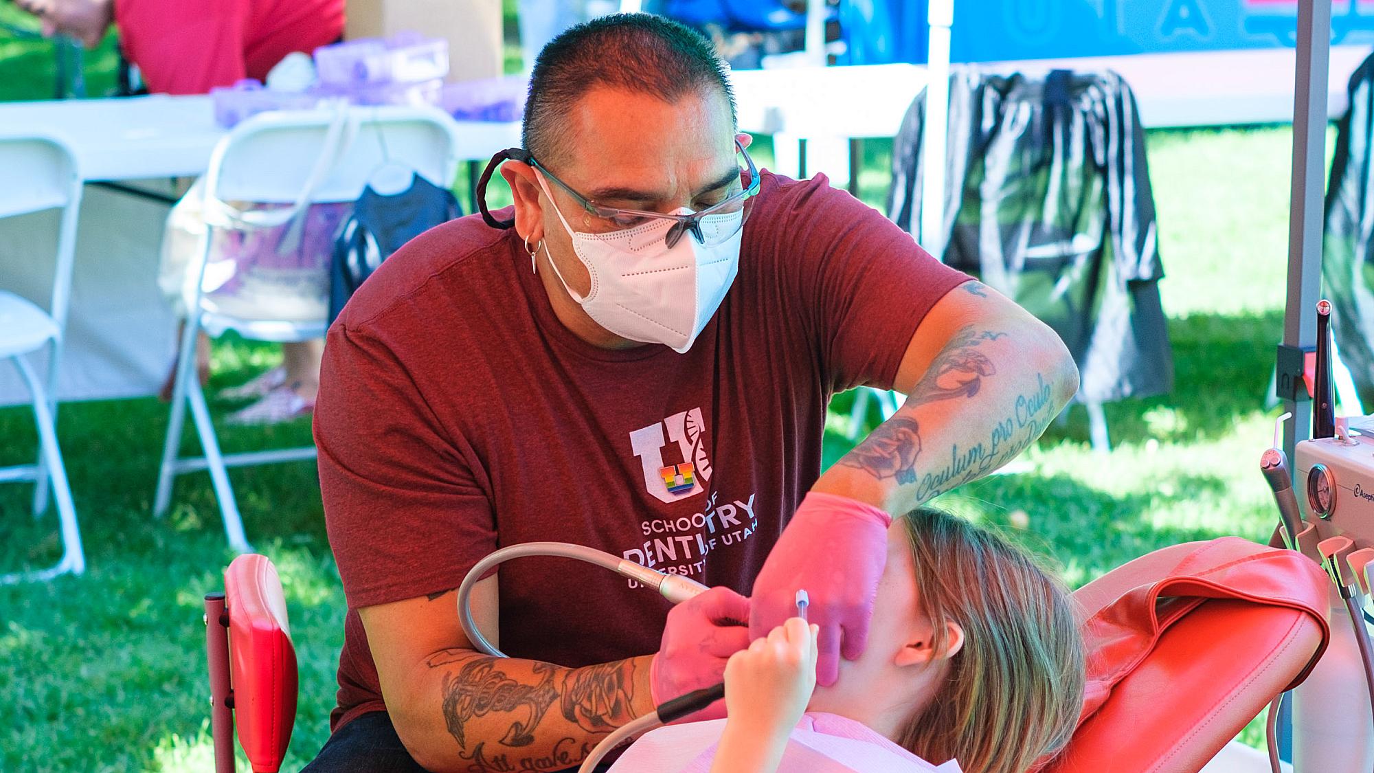 a dentistry volunteer cleans a child's teeth