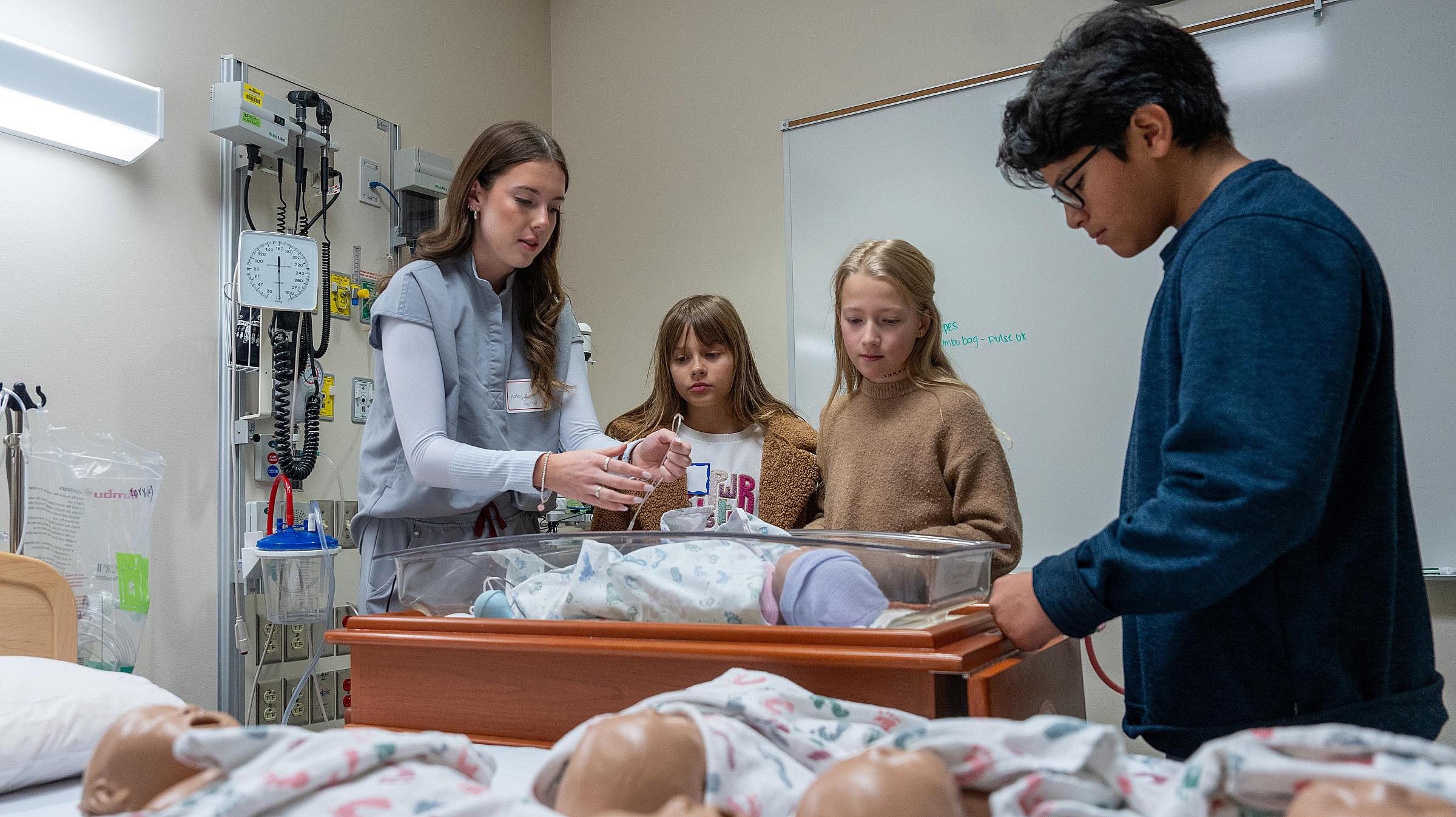Saturday Academy participants practice on baby mannequins in the College of Nursing Simulation Center