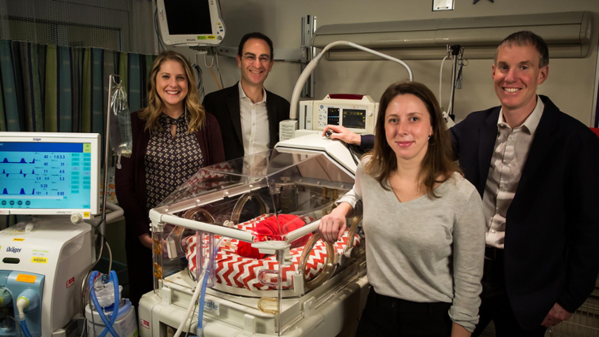 Four People around Baby in NICU for NeoSeq