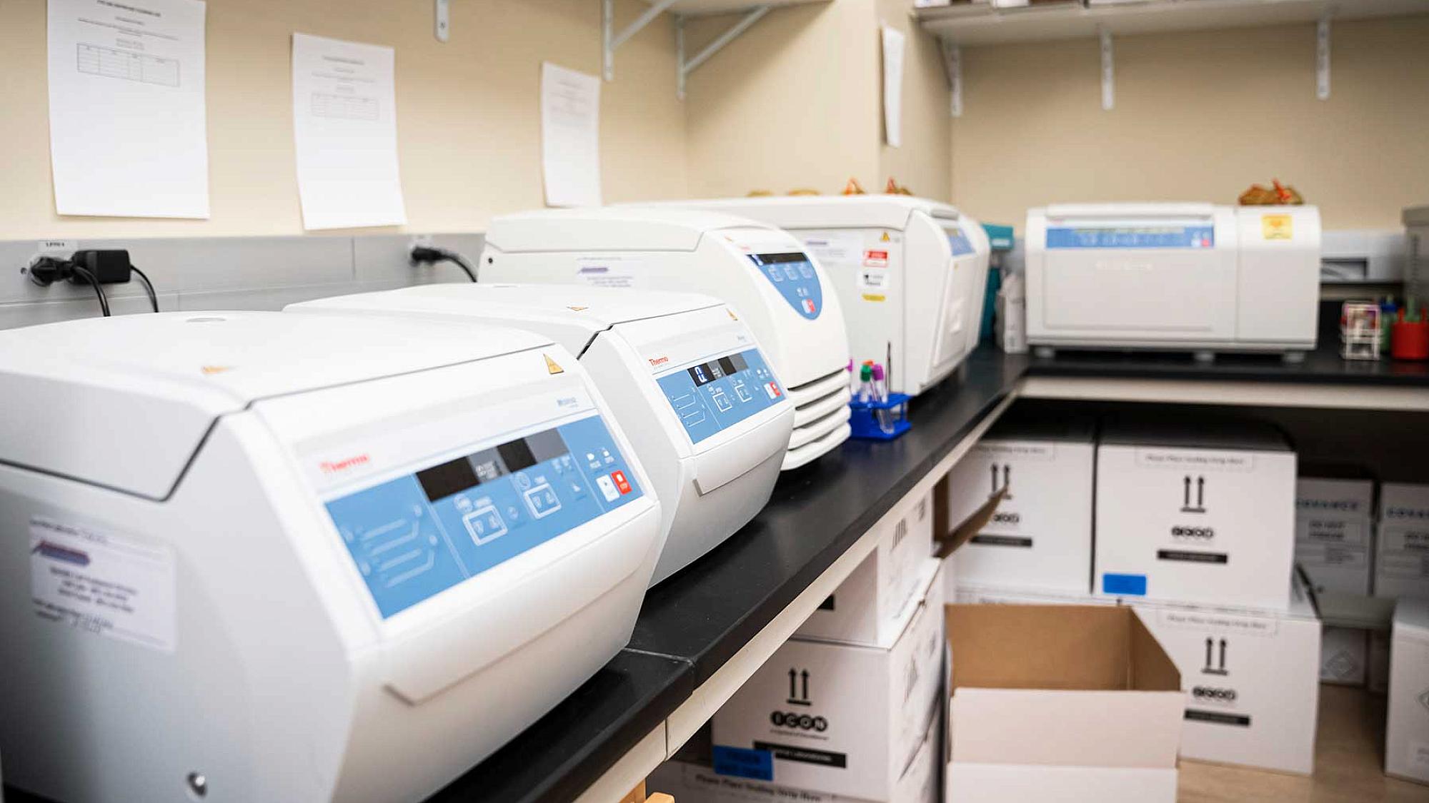 Row of refrigerated centrifuges on lab counter