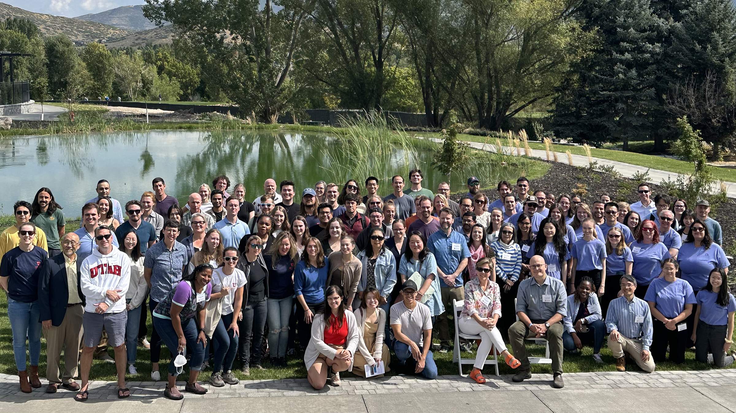 Group photo of all the research retreat attendees in front of a pond