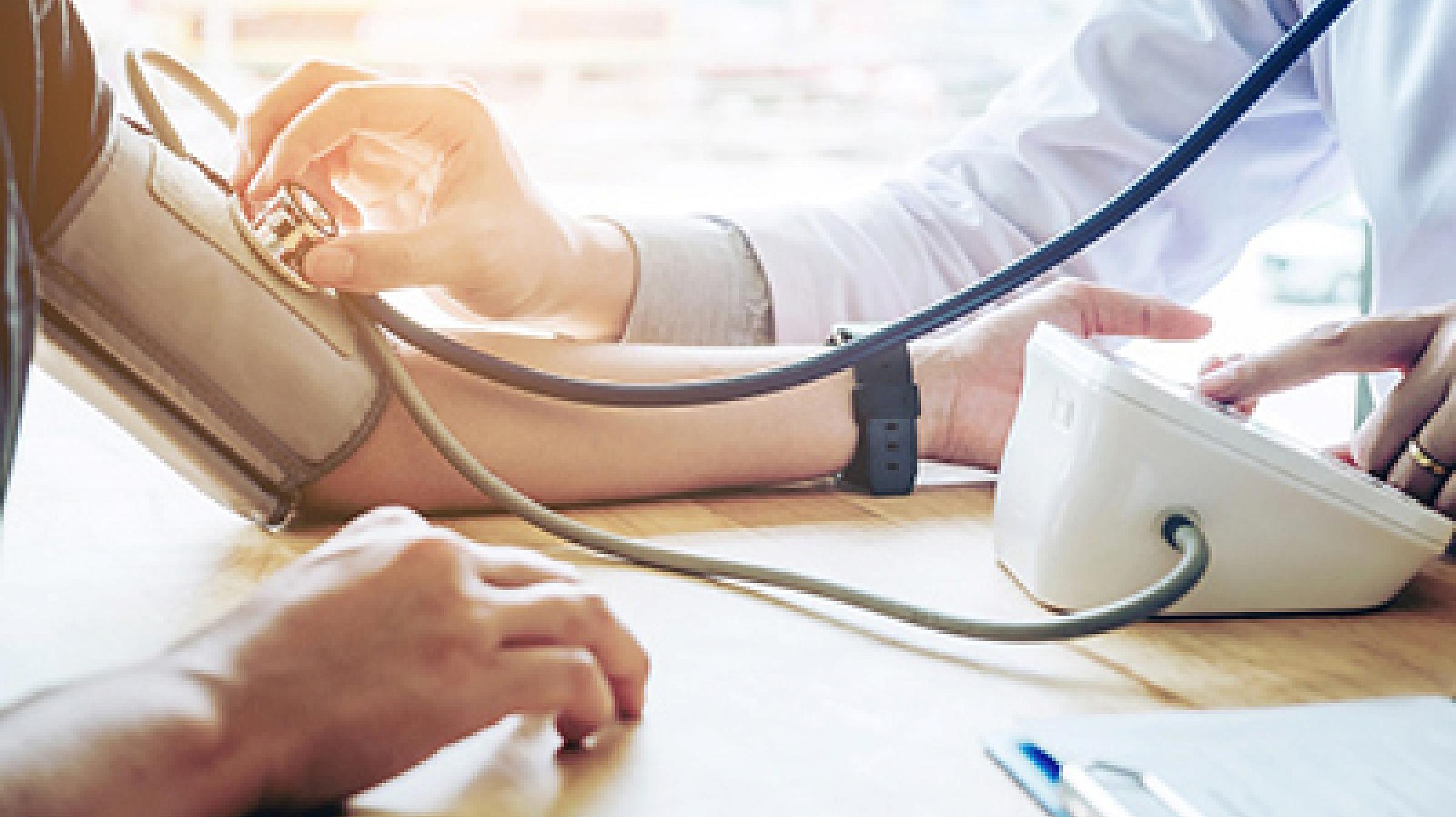 Patient has their blood pressure checked by a doctor