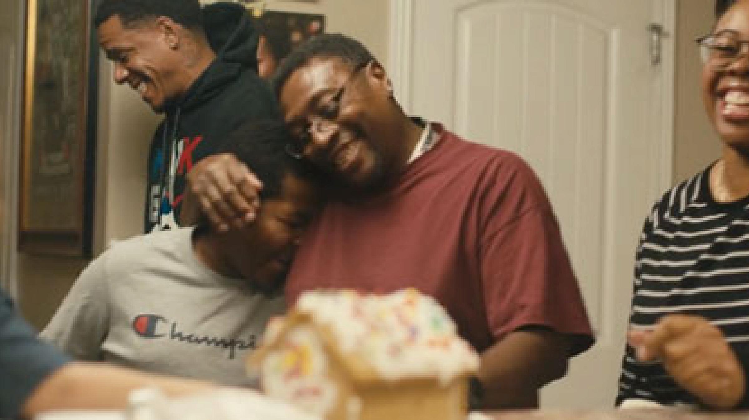 a family gathers around a table laughing and smiling